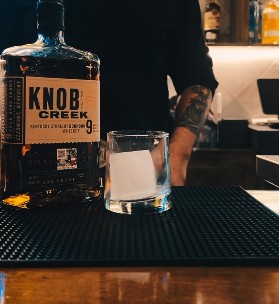 Bartender pouring a Godfather cocktail