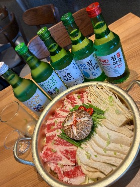 Soju bottles around a beef hot pot